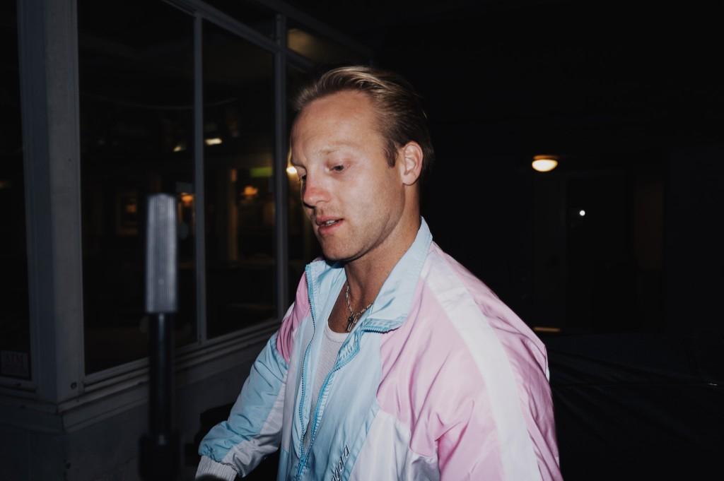 Luke Lively in a pastel windbreaker during a nighttime flash portrait